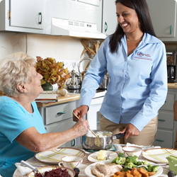 Comfort Keeper worker serving older woman food 