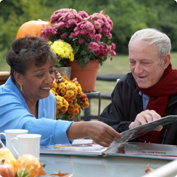 seniors looking at photo album outside 