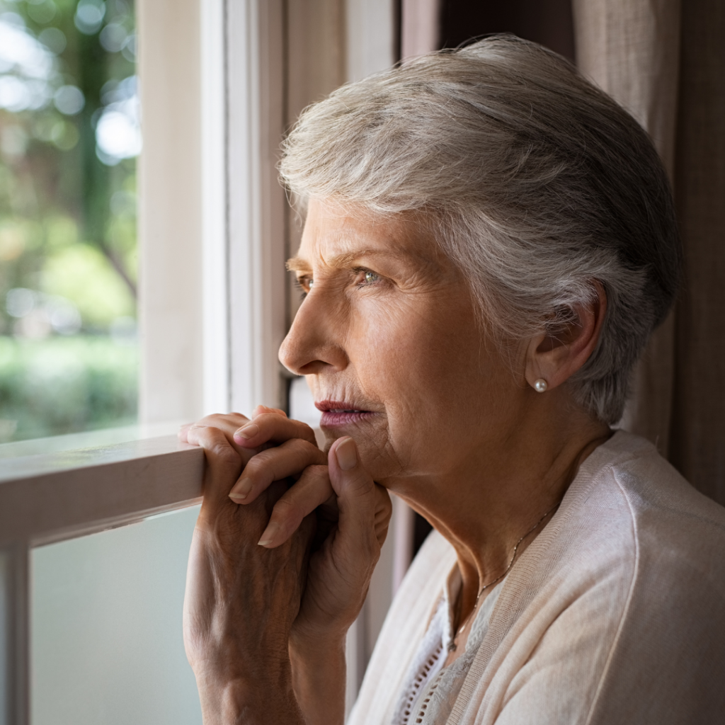 Senior Woman looking out window | Comfort Keepers Calgary | Combating Loneliness in Seniors | BLOG POST