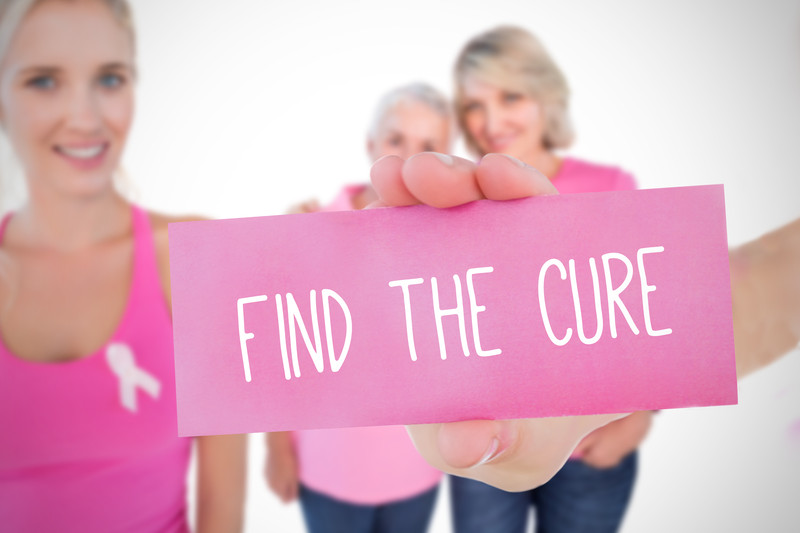 Two Senior Women holding a sign that reads: Find the Cure | Comfort Keepers Calgary | BLOG POST | Elderly Care and Breast Cancer