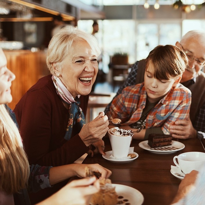 Seniors with younger generations seated at table and laughing | Comfort Keepers Calgary | BLOG POST | Preparing for the holidays