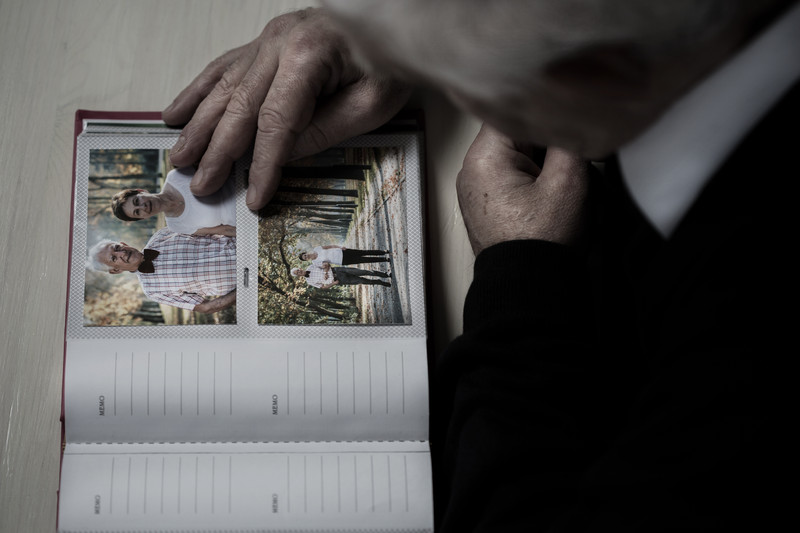 Senior male looking at photo album | Comfort Keepers Calgary | BLOG POST | Parkinson's Disease and Home Care