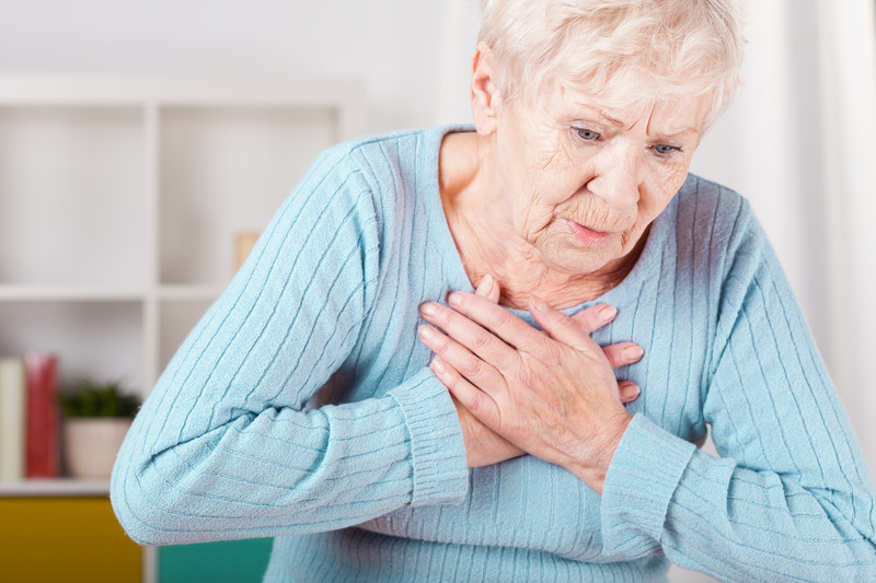 Senior woman seated clutching chest | Comfort Keepers Calgary | BLOG POST | Atrial Fibrillation in Seniors