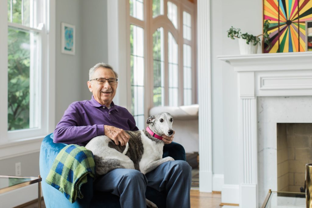 Senior Male seated on a chair with dog on lap | Vitamin B12 May Play a Role in Preventing Alzheimer's | BLOG POST | Comfort Keepers Calgary