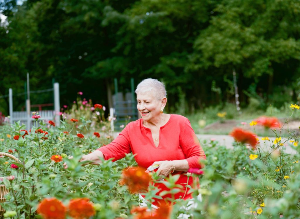 Senior woman out in a field of flowers | Comfort Keepers Calgary | BLOG POST | Summer Safety for Seniors