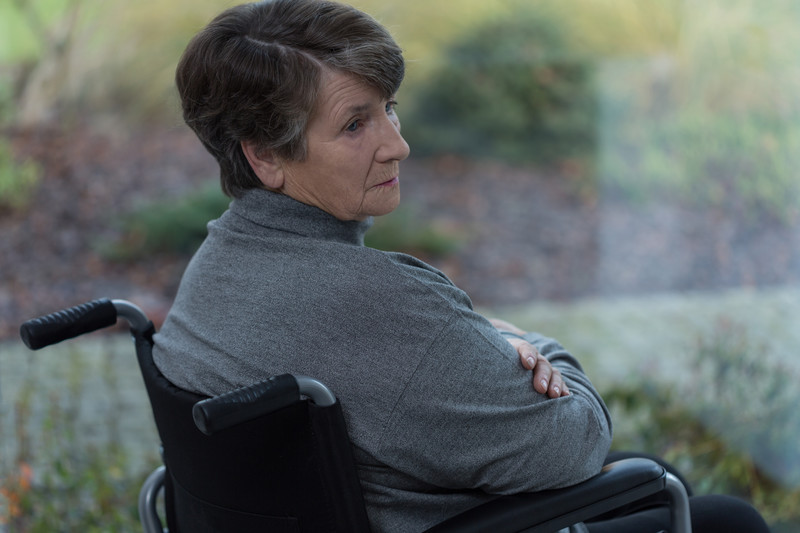 Senior woman seated in wheelchair looking over her shoulder | Comfort Keepers Calgary | BLOG POST | Managing Epilepsy in Seniors