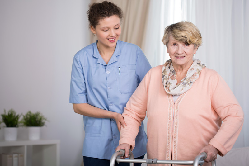 Senior woman walking with the assistance of a walker and caregiver | Comfort Keepers Calgary | BLOG POST | Senior Care after Knee and Hip Replacement