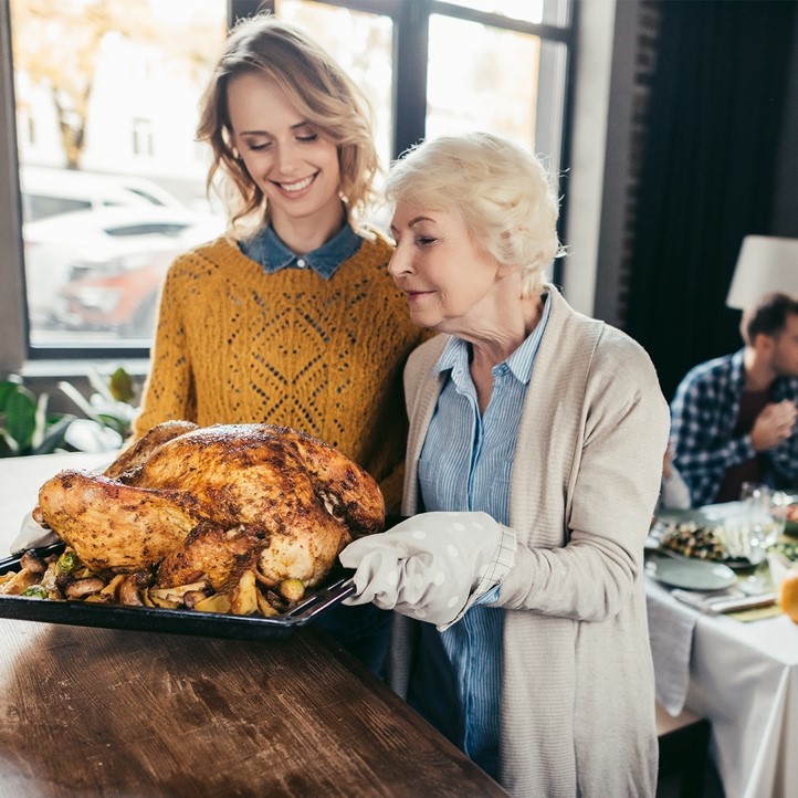 Senior mother with adult daughter looking at Christmas turkey | Checking in on loved ones this holiday season | BLOG POST | Comfort Keepers Calgary
