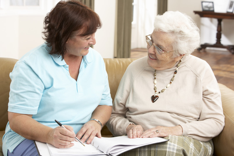 Senior woman seated on couch with caregiver | Comfort Keepers Calgary | BLOG POST | Elderly Home Care Services Can Help With Rehab