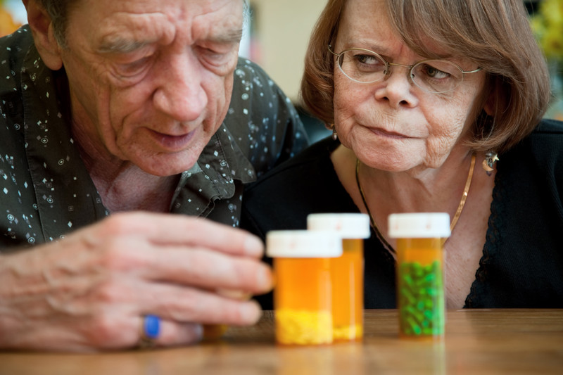 Seniors looking at medication bottles | Medication Safety for Seniors | Comfort Keepers Edmonton | BLOG POSR