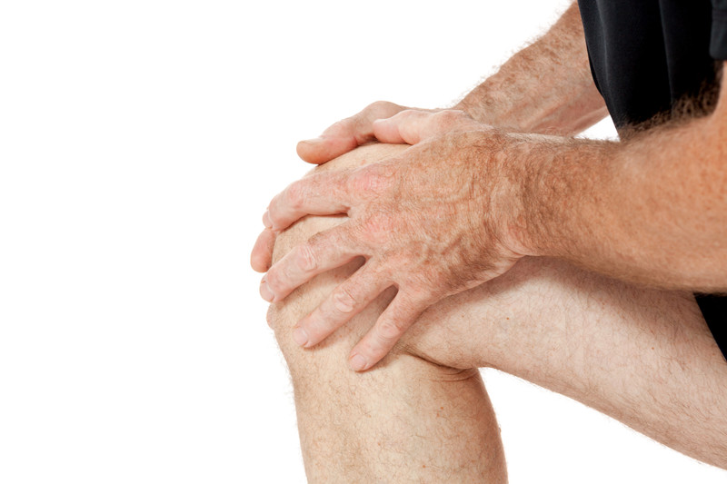 Living With Arthritis | Comfort Keepers Edmonton | BLOG POST | Male holding knee presumably in pain