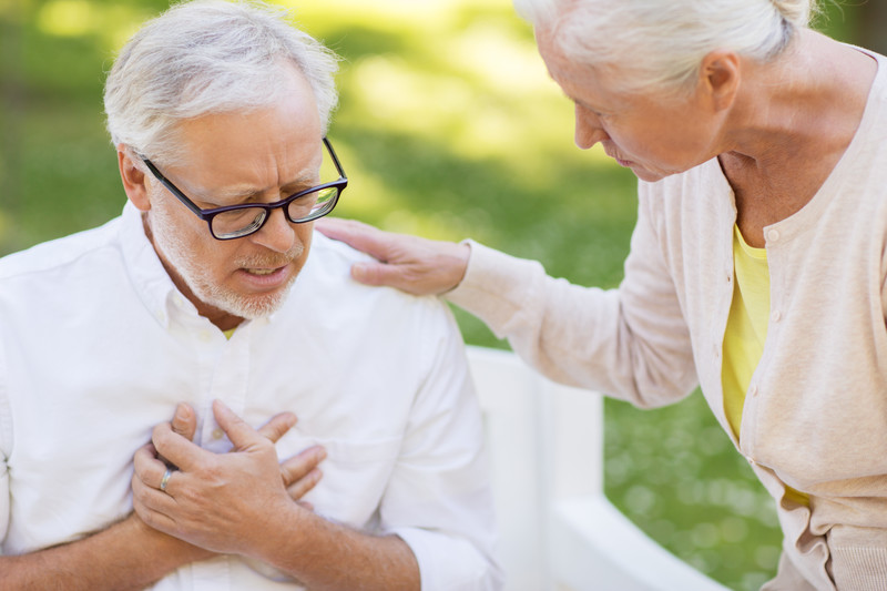 Top 5 Signs & Symptoms of a Stroke | Comfort Keepers Edmonton | BLOG POST | Image shows senior male clutching chest with senior women overlooking