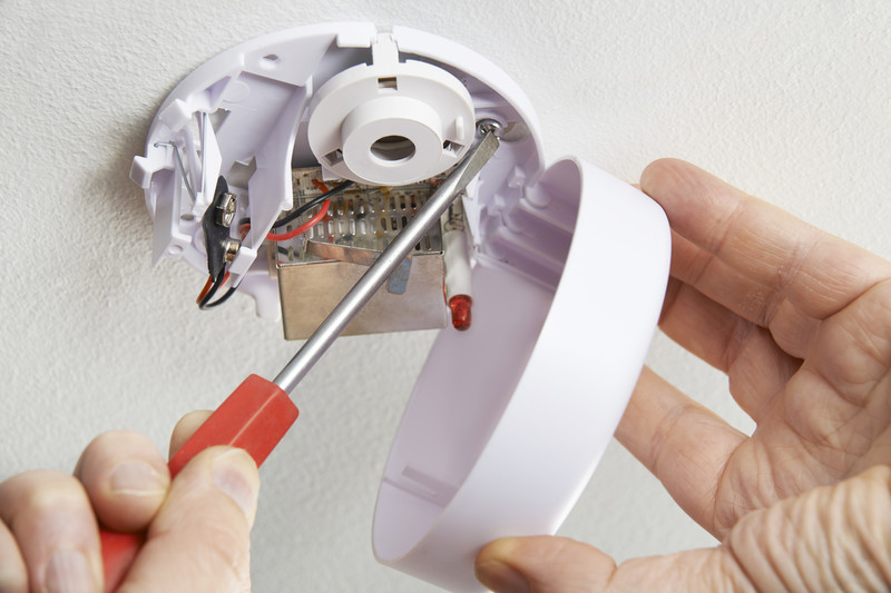 Someone installing a fire alarm | Fire Safety Tips for Seniors | Comfort Keepers Edmonton | BLOG POST