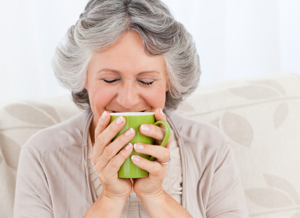 Help Seniors Prevent Dehydration | Senior Women sipping from a tea mug | Comfort Keepers Edmonton | BLOG POST