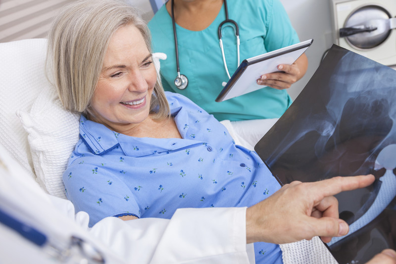 Senior Knee or Hip Replacement | Comfort Keepers Edmonton | BLOG POST | Image of senior woman in bed while medical staff show her xrays