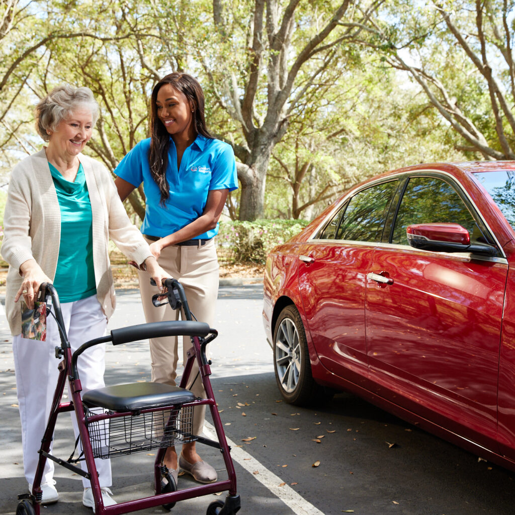 An older woman using a walker with the assistance of a Comfort Keepers caregiver, promoting mobility and daily steps.
