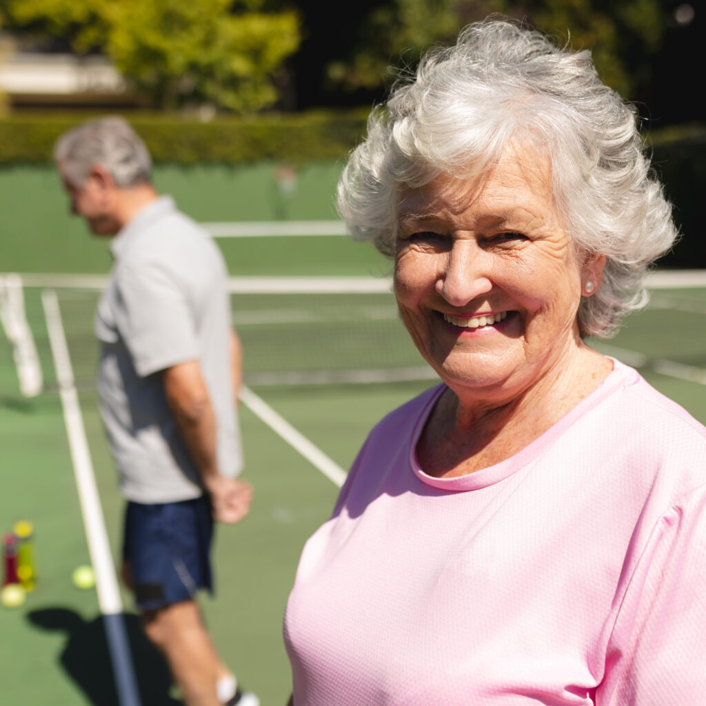 Smiling senior woman representing the improved mood and mental well-being that come from playing Pickleball.
