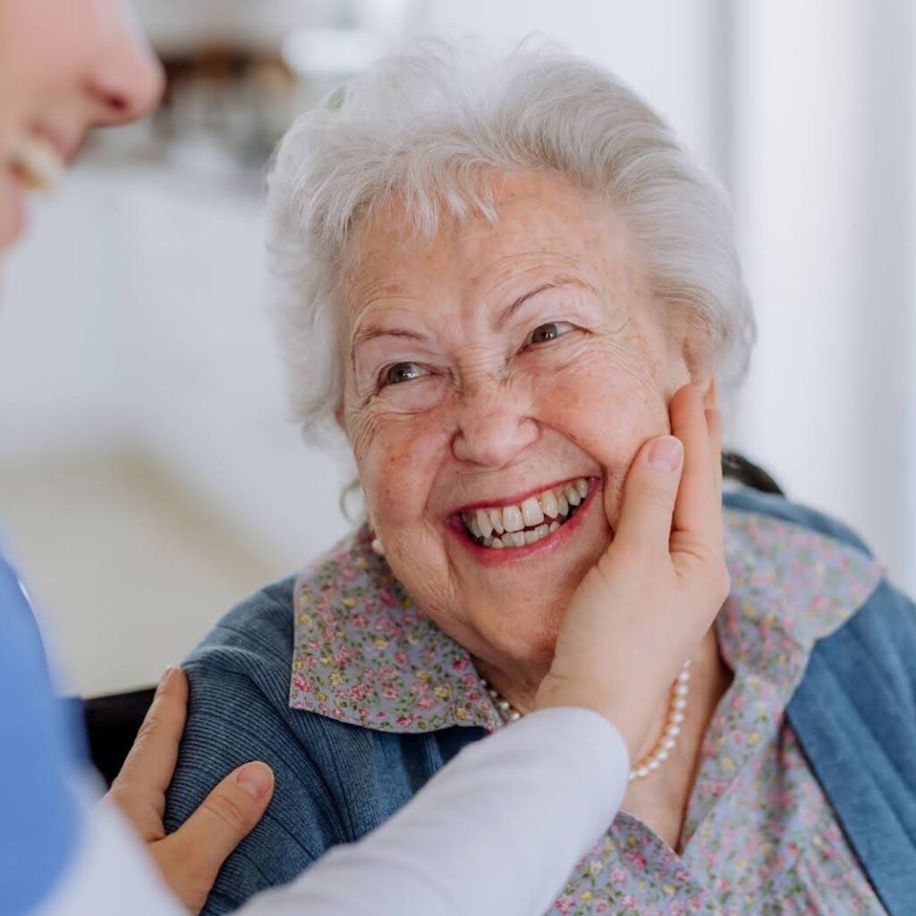 Smiling senior woman receiving gentle care from caregiver in Guelph home