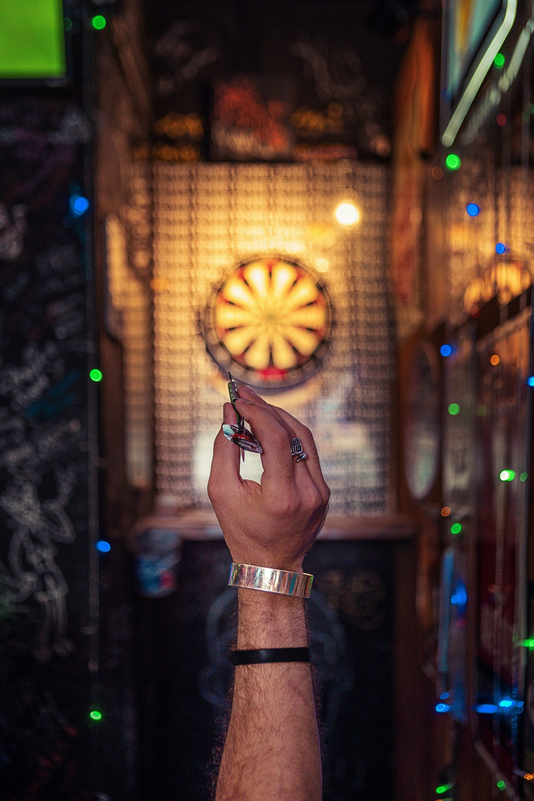 A person holding a dart, readying to throw it at a dartboard; a metaphor for yet another unspoken challenge in retirement