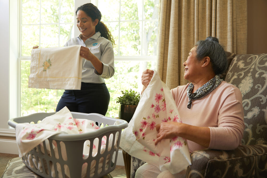 caregivers give support to senior for laundry