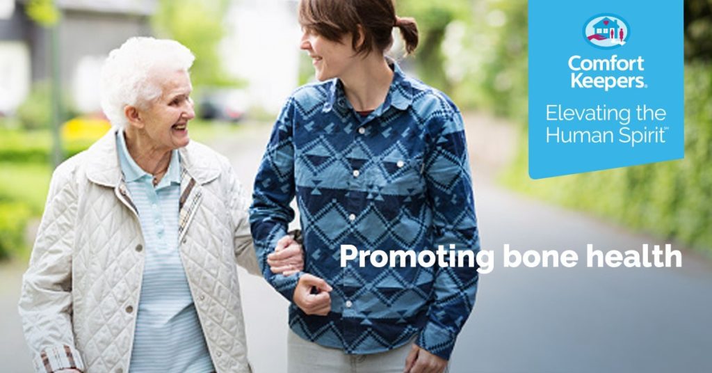 Two aging adults walking down the street holding hands | Promoting Bone Health | Comfort Keepers North and West Vancouver