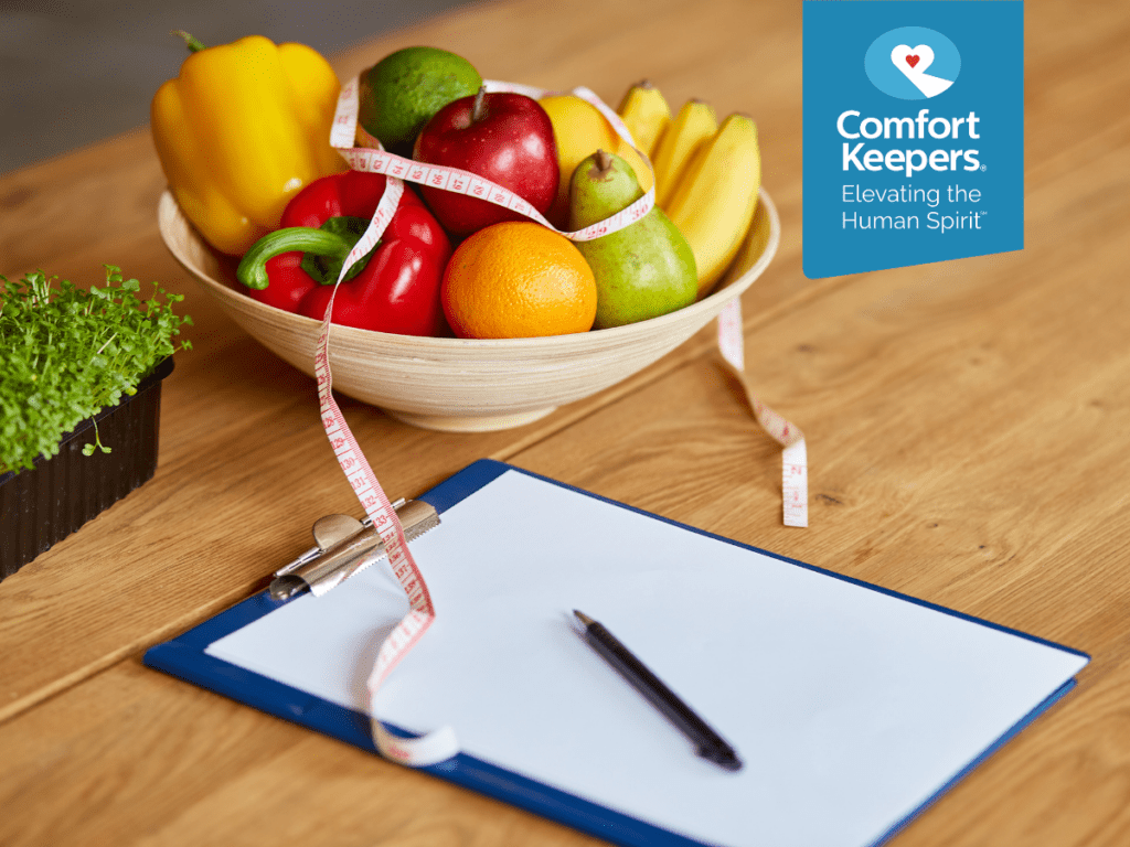 A bowl of fruit sits on a table beside a container of sprouts, measuring tape and a clipboard | Healthy Eating Tips for Seniors on a Fixed Income in North and West Vancouver | Comfort Keepers North and West Vancouver