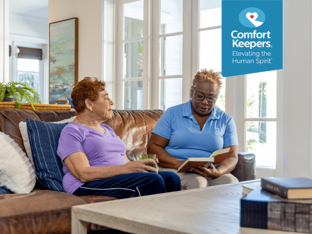 A caregiver reads a book to her senior client | Improve Your Senior’s Memory with These 8 Tips | Comfort Keepers North and West Vancouver