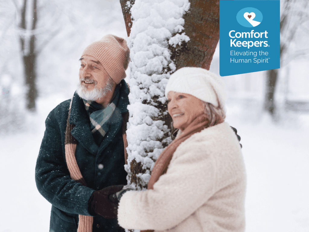 Two seniors stand beside a snow covered tree | Senior Winter Safety: Keeping British Columbians Safe During Inclement Weather | Comfort Keepers North and West Vancouver