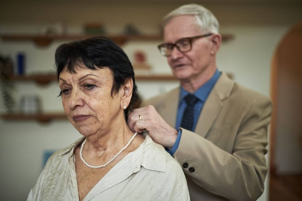 Senior man helping his wife put on a necklace, showing the importance of daily assistance in home care Ottawa.