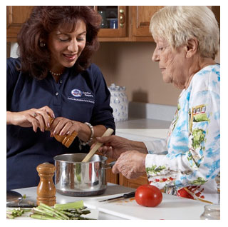 Penny, the Comfort Keepers caregiver assists female senior client in cooking.

