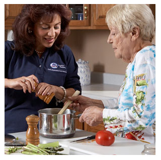 Penny, the Comfort Keepers caregiver assists female senior client in cooking.

