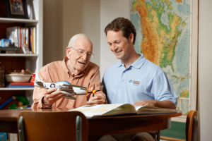 Teddy, the Comfort Keepers caregiver, having fun playing with senior client in the library.
