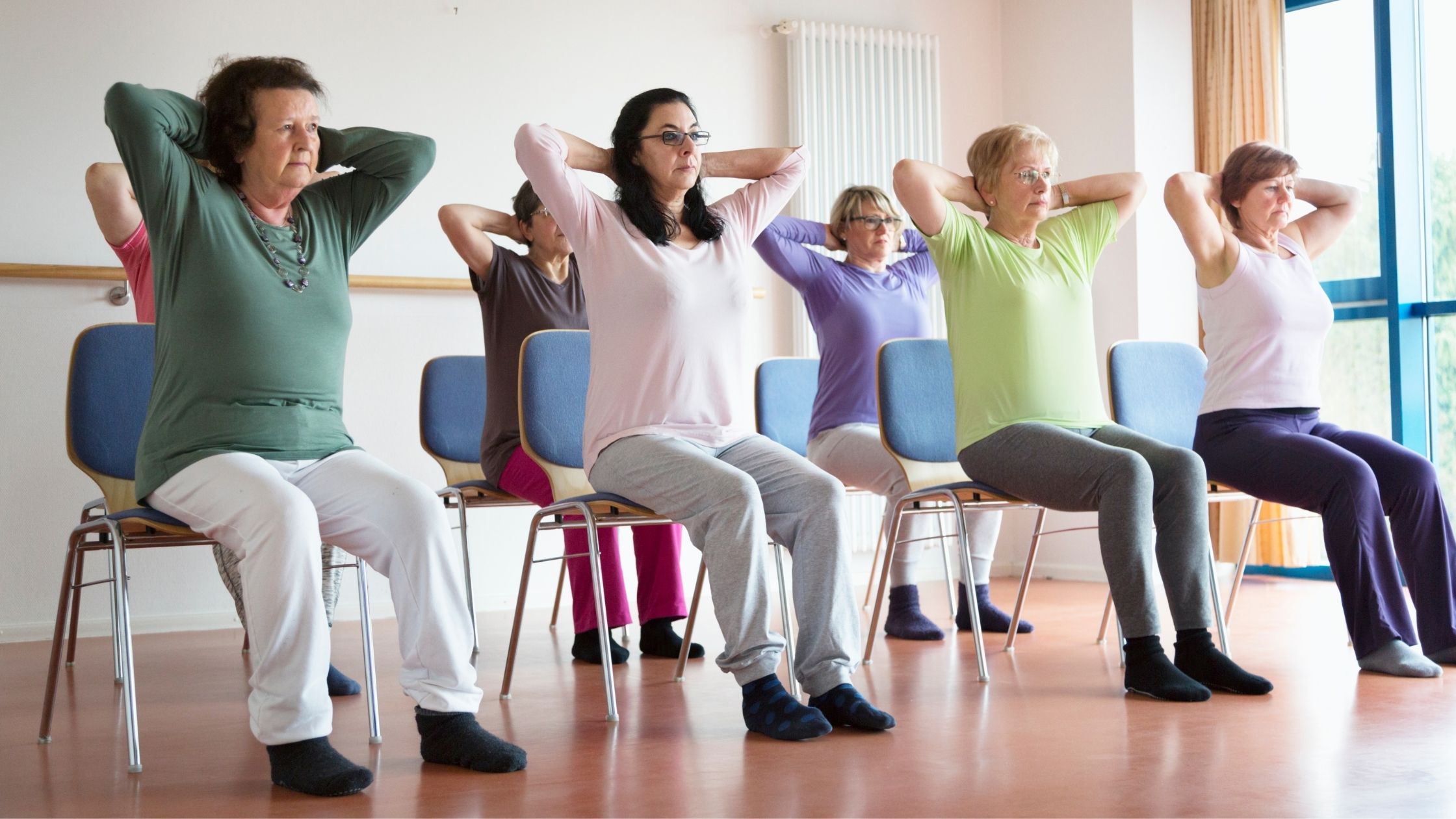 Seniors sitting in chairs in various yoga poses