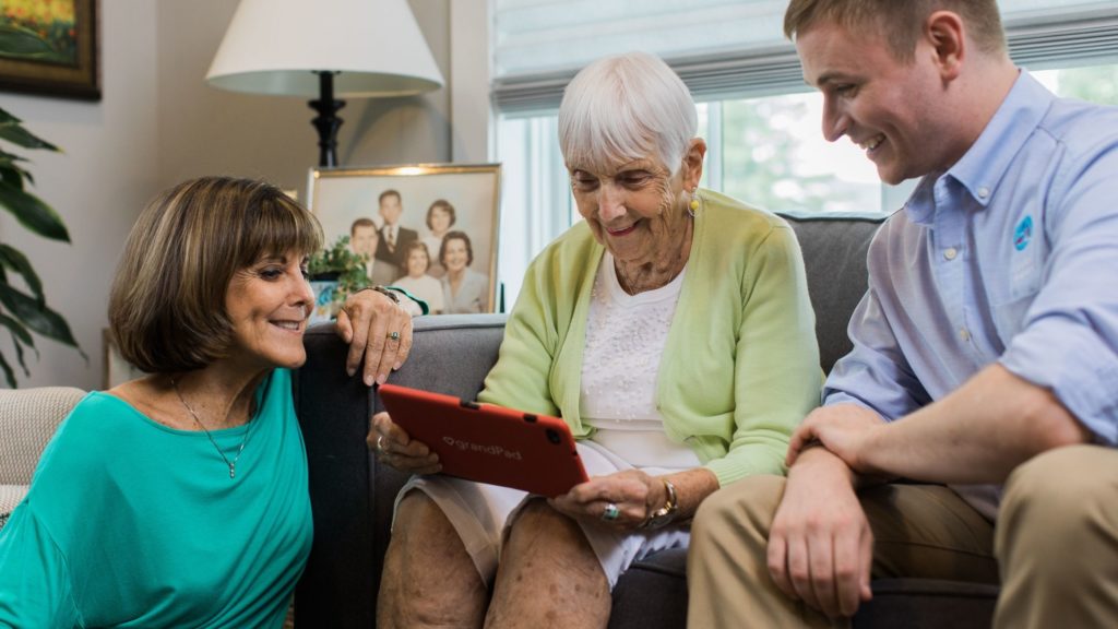 Family caregiver and senior woman sitting with in-home senior caregiver 