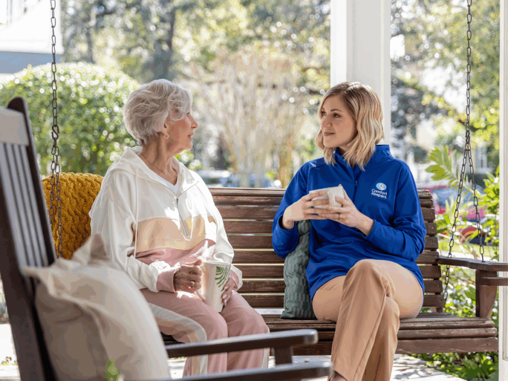 Senior sitting on front porch with caregiver enjoying a hot beverage | Preventing Unintentional Weight Loss in Seniors: Nurturing Health with Every Bite | Comfort Keepers Regina | BLOG POST