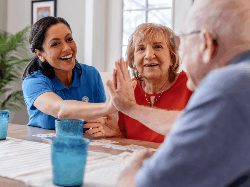 A senior couple high fives a caregiver | A Family Guide to In-Home Care Needs Assessment & Personalized Planning | Comfort Keepers Ridge Meadows | BLOG POST