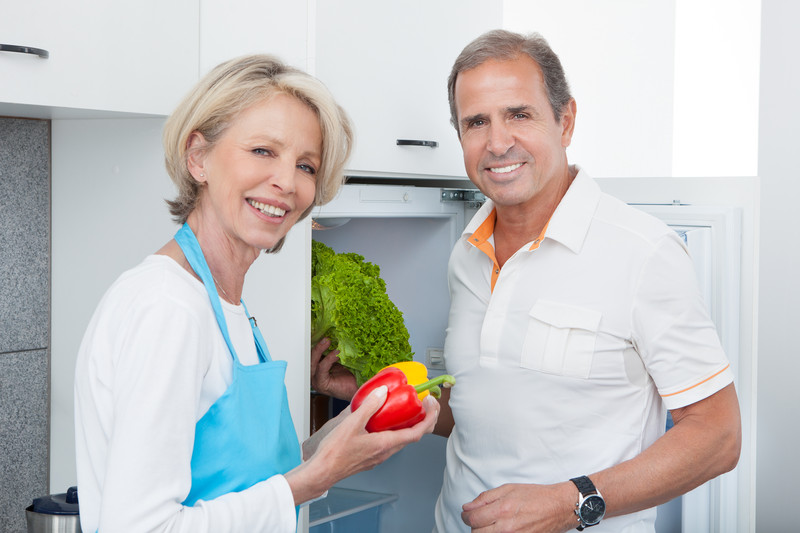 Senior and caregiver standing in front of fridge with healthy food | Obesity in Seniors | BLOG POST | Comfort Keepers Vancouver