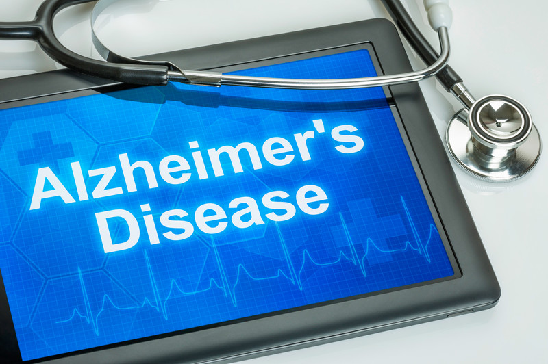 Photo of table with Alzheimer's Disease displayed on screen | Alzheimer's Signs and Symptoms | BLOG POST | Comfort Keepers Vancouver