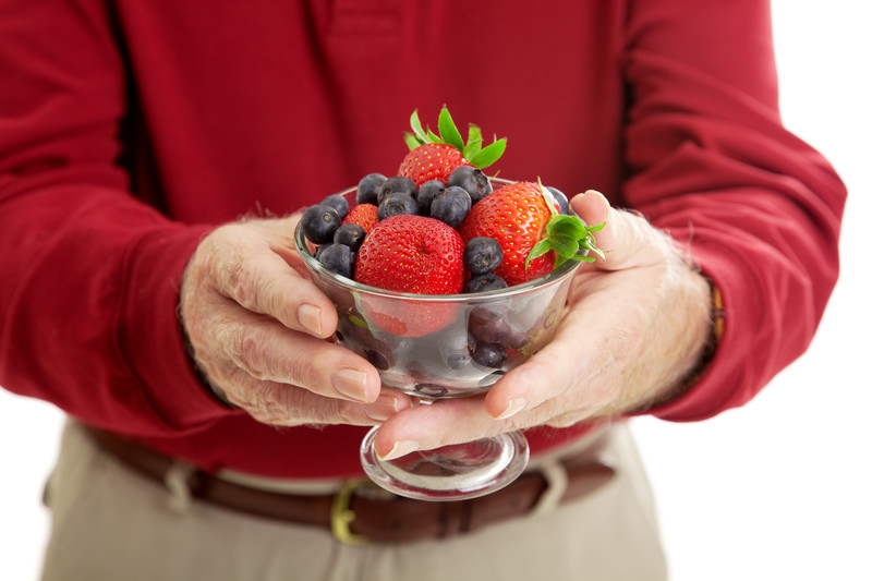 Individual in red shirt presenting a bowl of berries | Proper Portions at Meal Time | BLOG POST | Comfort Keepers Vancouver