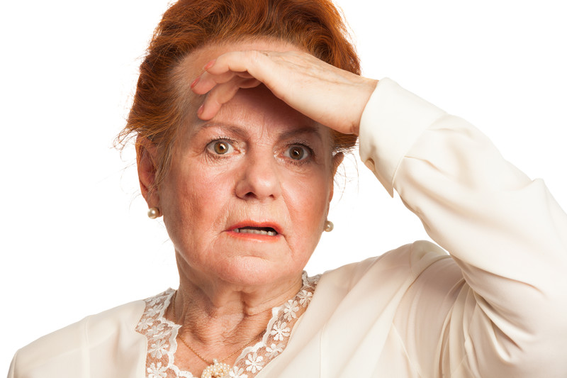 Senior women holding hand to forehead with look of concern | Stress Relief Techniques for Seniors | BLOG POST | Comfort Keepers Victoria