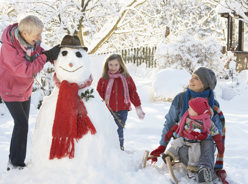 Senior building a snowman with family | In-Home Senior Care Services | BLOG POST | Comfort Keepers Victoria