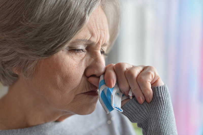 Senior woman with hand to mouth | Pneumonia in Seniors | Comfort Keepers Victoria | BLOG POST