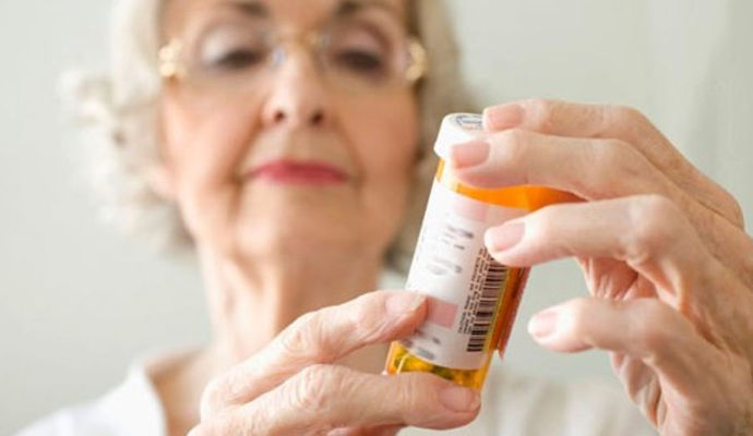 Senior Women examining medication bottle | Senior Medications | BLOG POST | Comfort Keepers Victoria